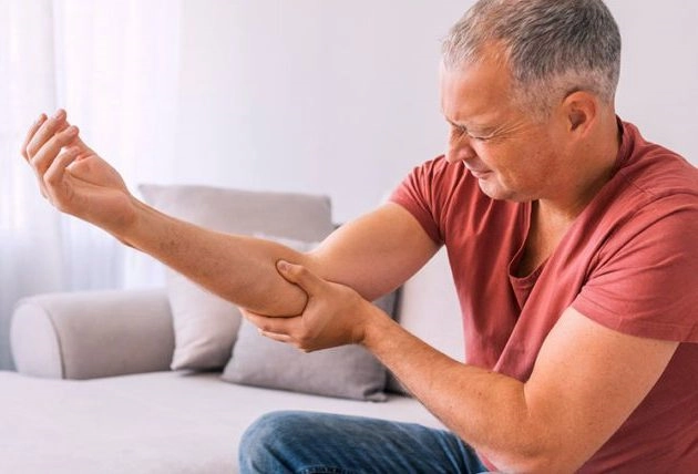 man with arthritis pain in elbow